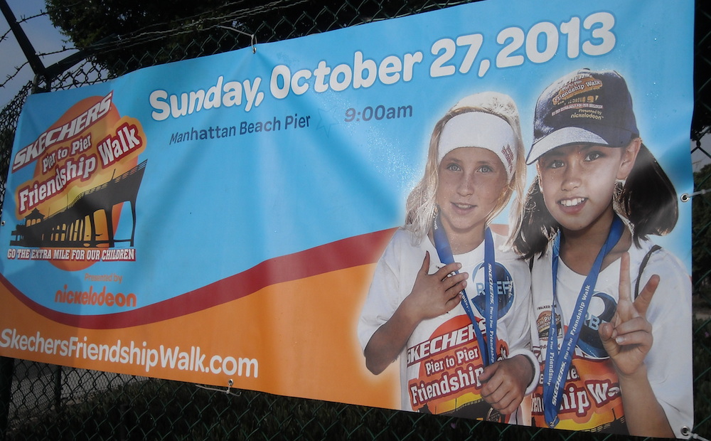 Theresa and friend Eden on poster for Skechers Pier to Pier Friendship Walk in Manhattan Beach, California for Movies Grow English, Learn English with Movies.